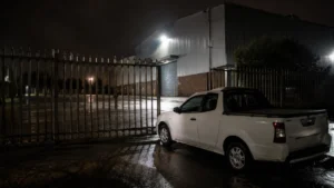 Security response vehicle at an empty warehouse gate after repeated false alarm call-outs